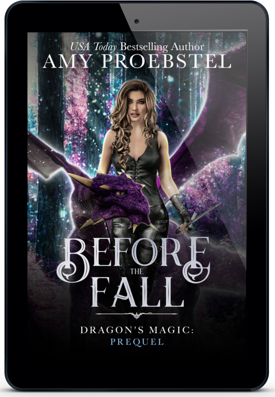 A tablet device displaying the book cover for 'Before the Fall: Dragon's Magic: Prequel' by Amy Proebstel. The cover art features a fantasy scene with a woman holding a purple dragon against a cosmic, starry background.