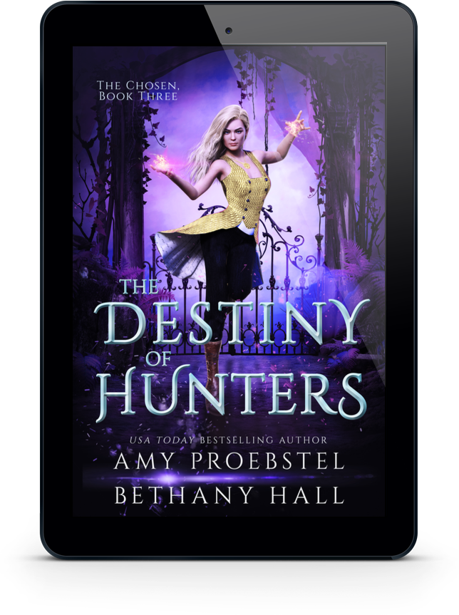 A black tablet device centered on a white background, displaying the book cover for 'The Destiny of Hunters' by Amy Proebstel and Bethany Hall. The cover art shows a fantasy scene with a woman in a yellow and black dress against a purple forest backdrop.