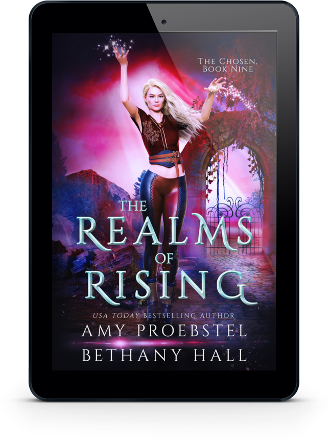 A black tablet device centered on a light gray background, displaying the book cover for 'The Realms of Rising' by Amy Proebstel and Bethany Hall.